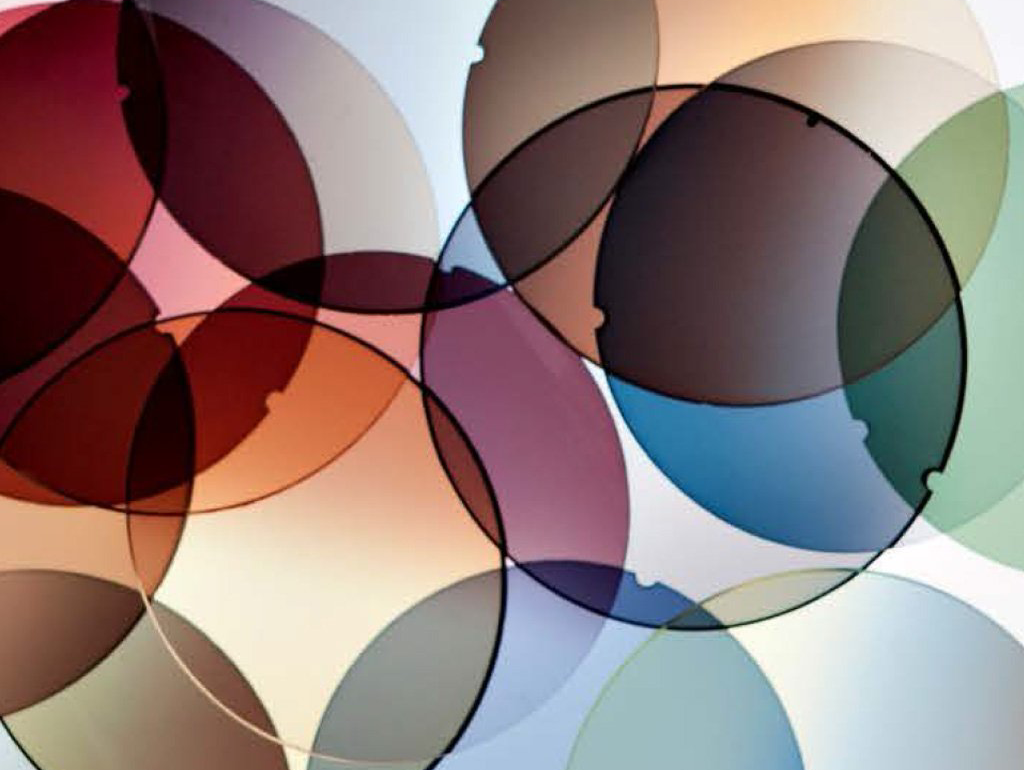 Overlapping colored circular shapes in shades of red, purple, blue, and yellow on a white background.
