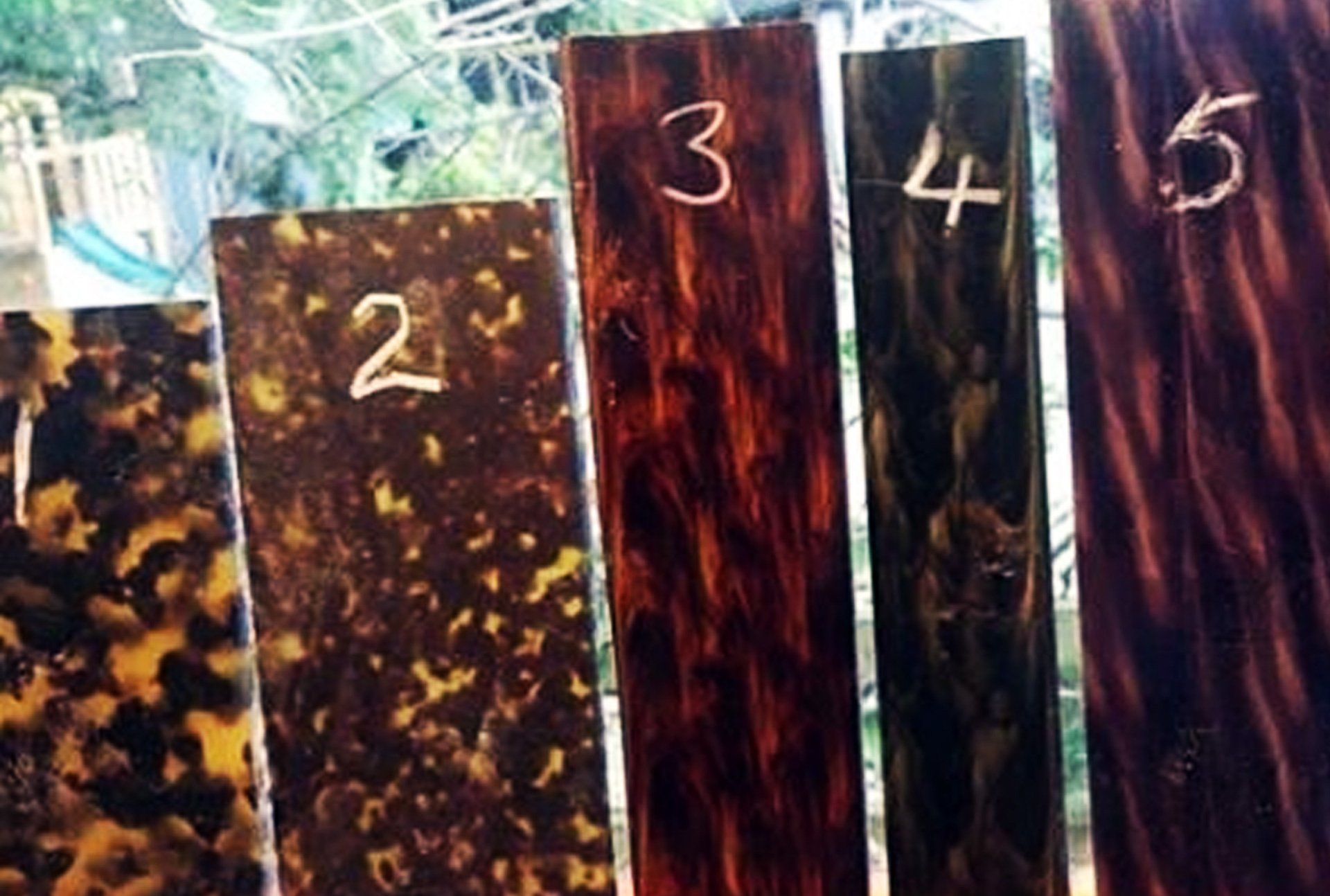 Five rectangular pieces of tortoiseshell-patterned material, numbered 1 through 5, in varying shades of brown and yellow.