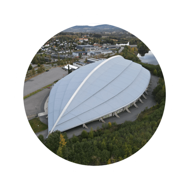 An aerial view of a large stadium surrounded by trees
