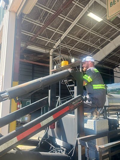 A man is working on a machine in a warehouse.