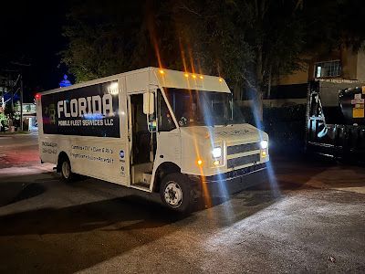 A white van is parked on the side of the road at night.