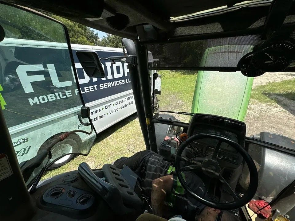 The inside of a tractor with a mobile fleet company van in the background