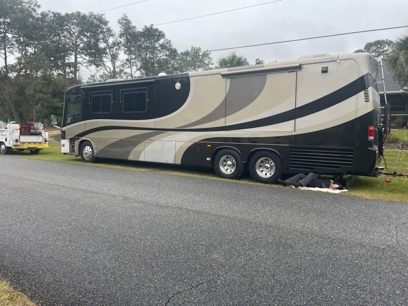 A large rv is parked on the side of the road.