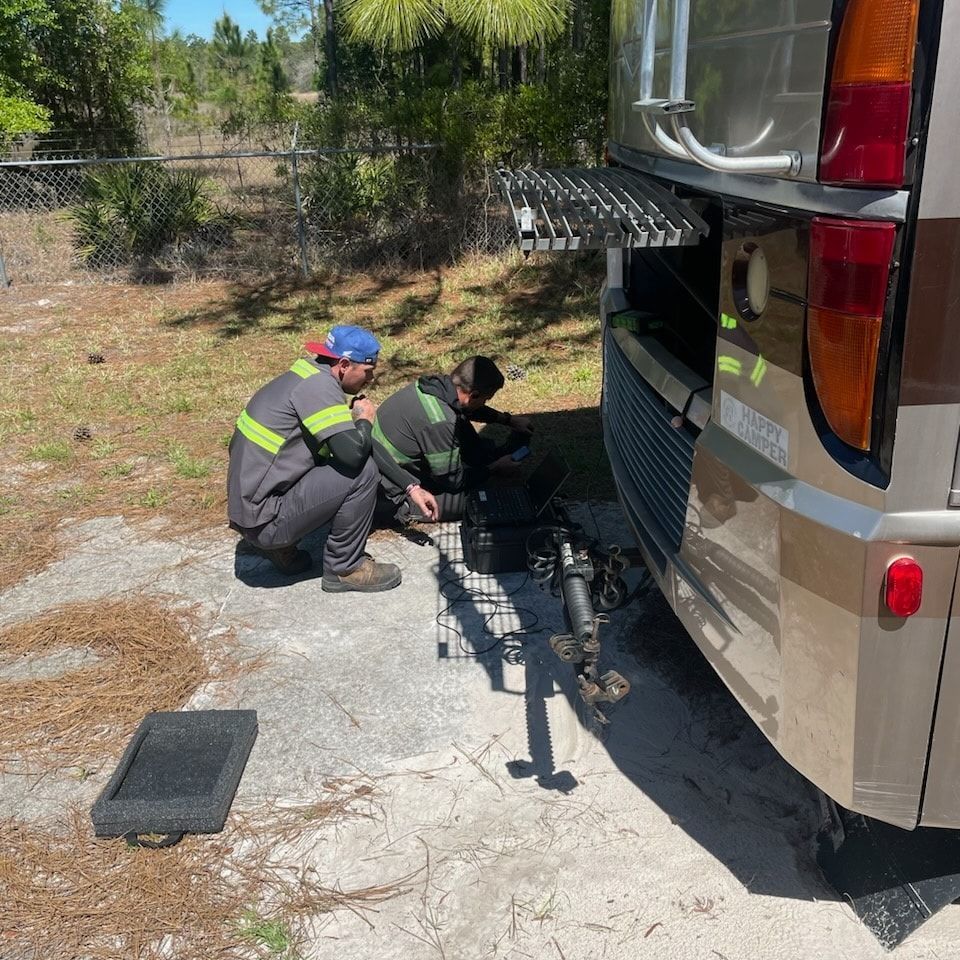 Two men are working on the back of a rv