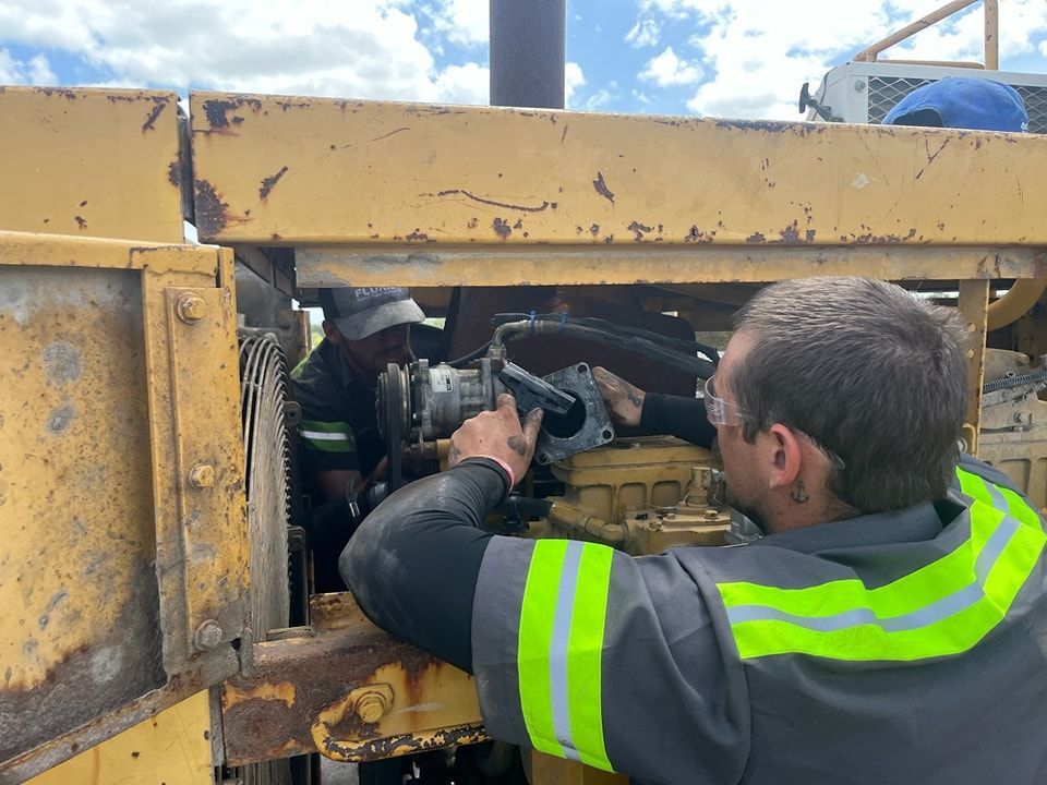 A man in a safety vest is working on a machine.