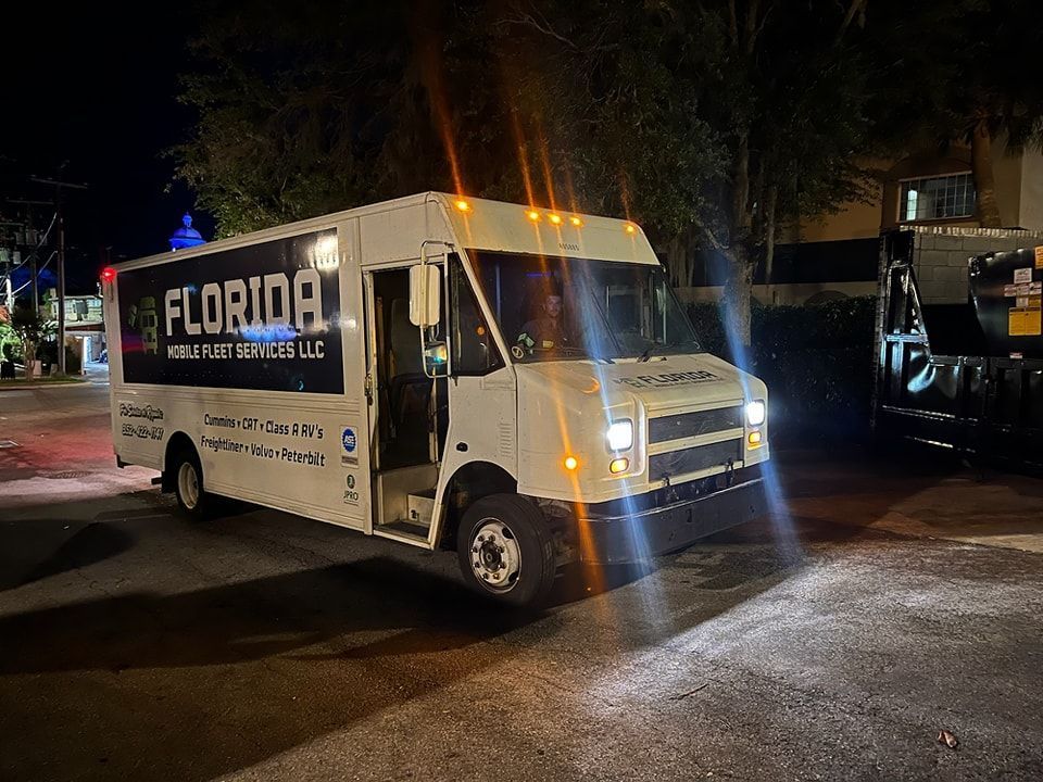 A white van is parked on the side of the road at night.