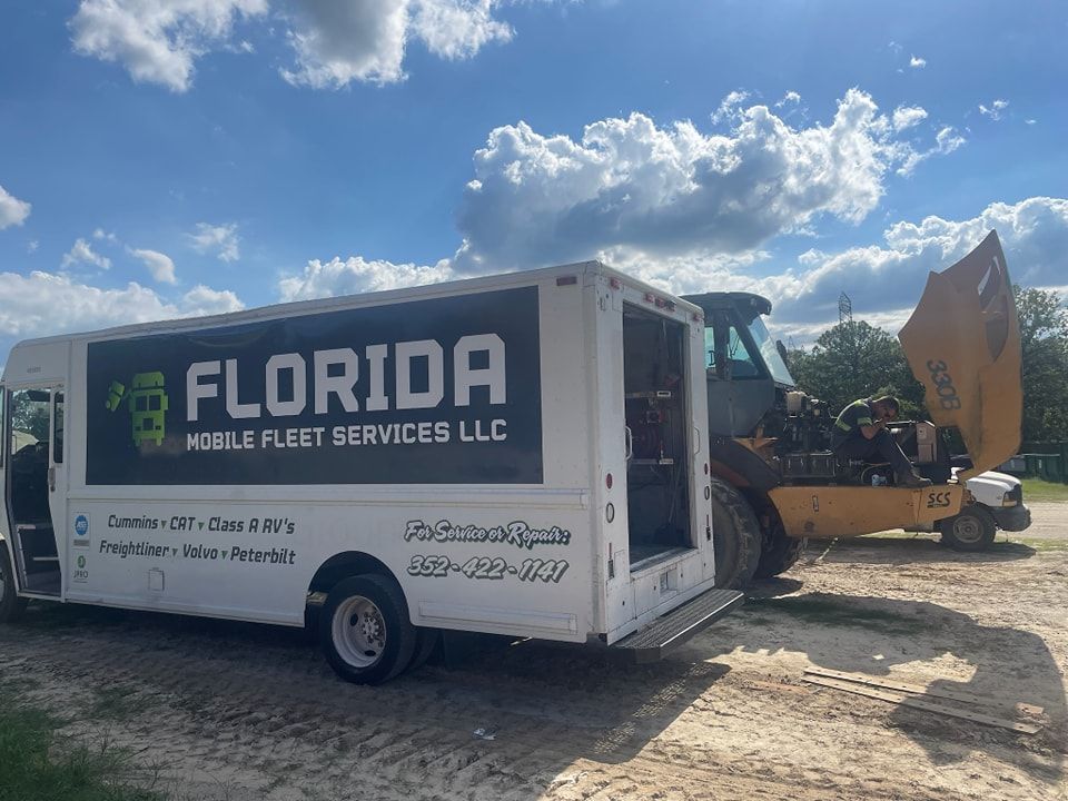 A florida mobile fleet services llc truck is parked next to a bulldozer.