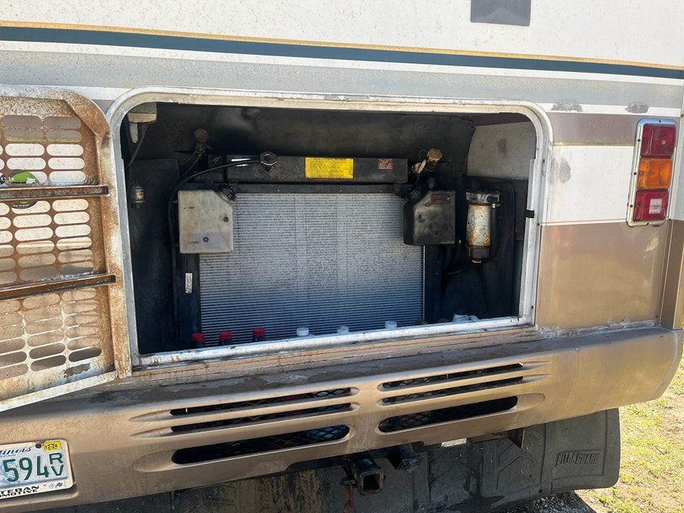 The back of a truck with the door open and a battery in the back.