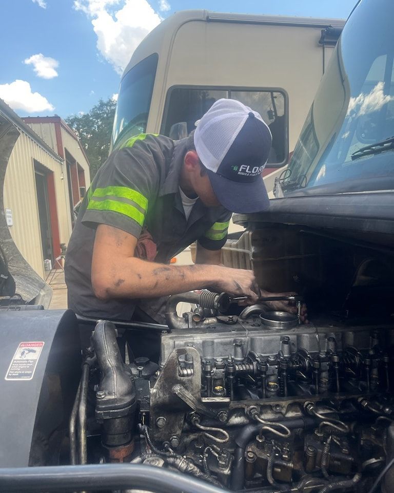 A man is working on the engine of a truck.
