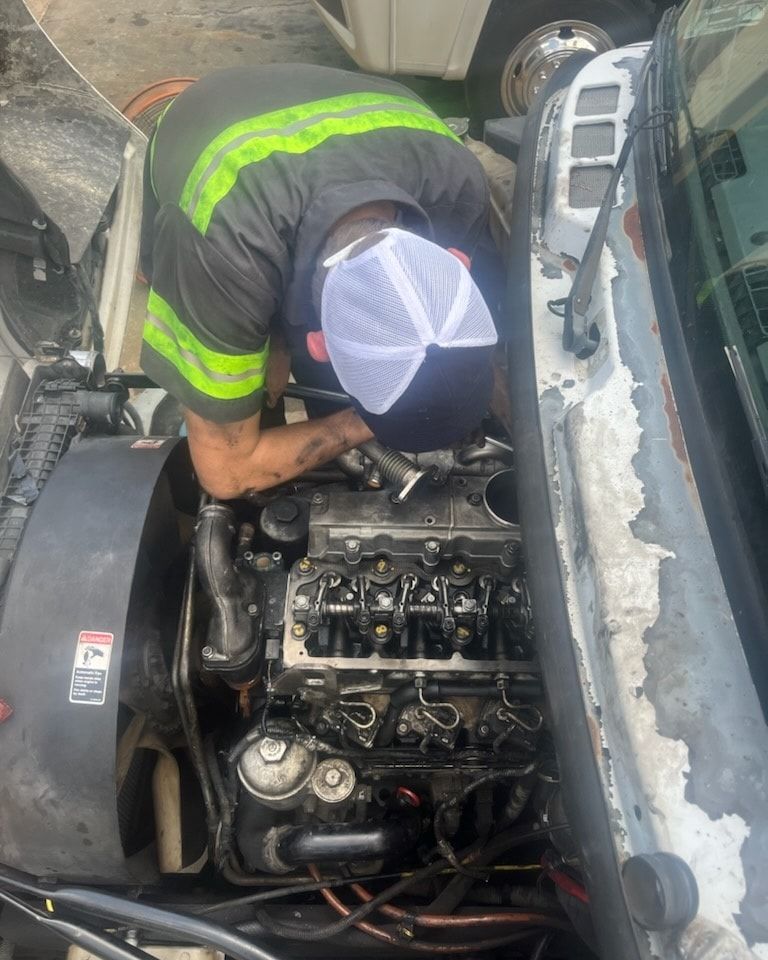 A man is working on the engine of a truck.