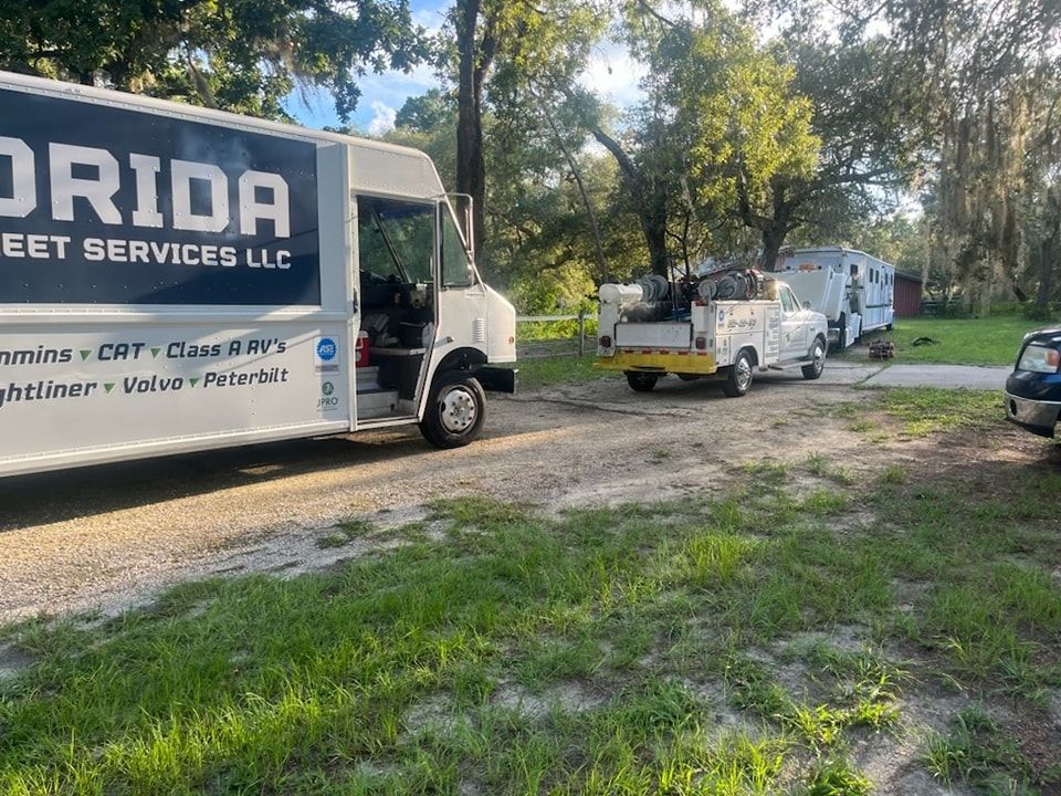 A white truck with the word florida on it is parked in a grassy field.