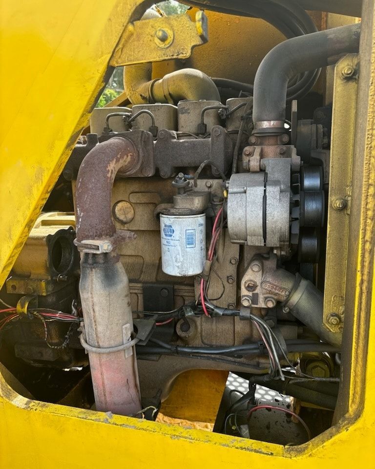 A close up of the engine of a yellow vehicle.