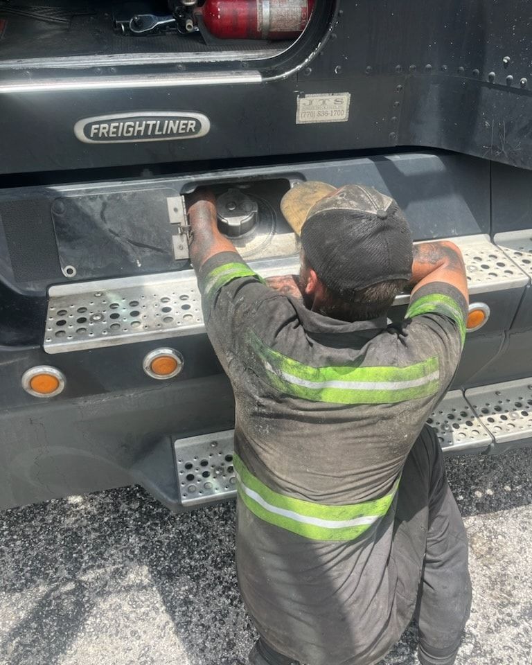 A man is working on the back of a truck.