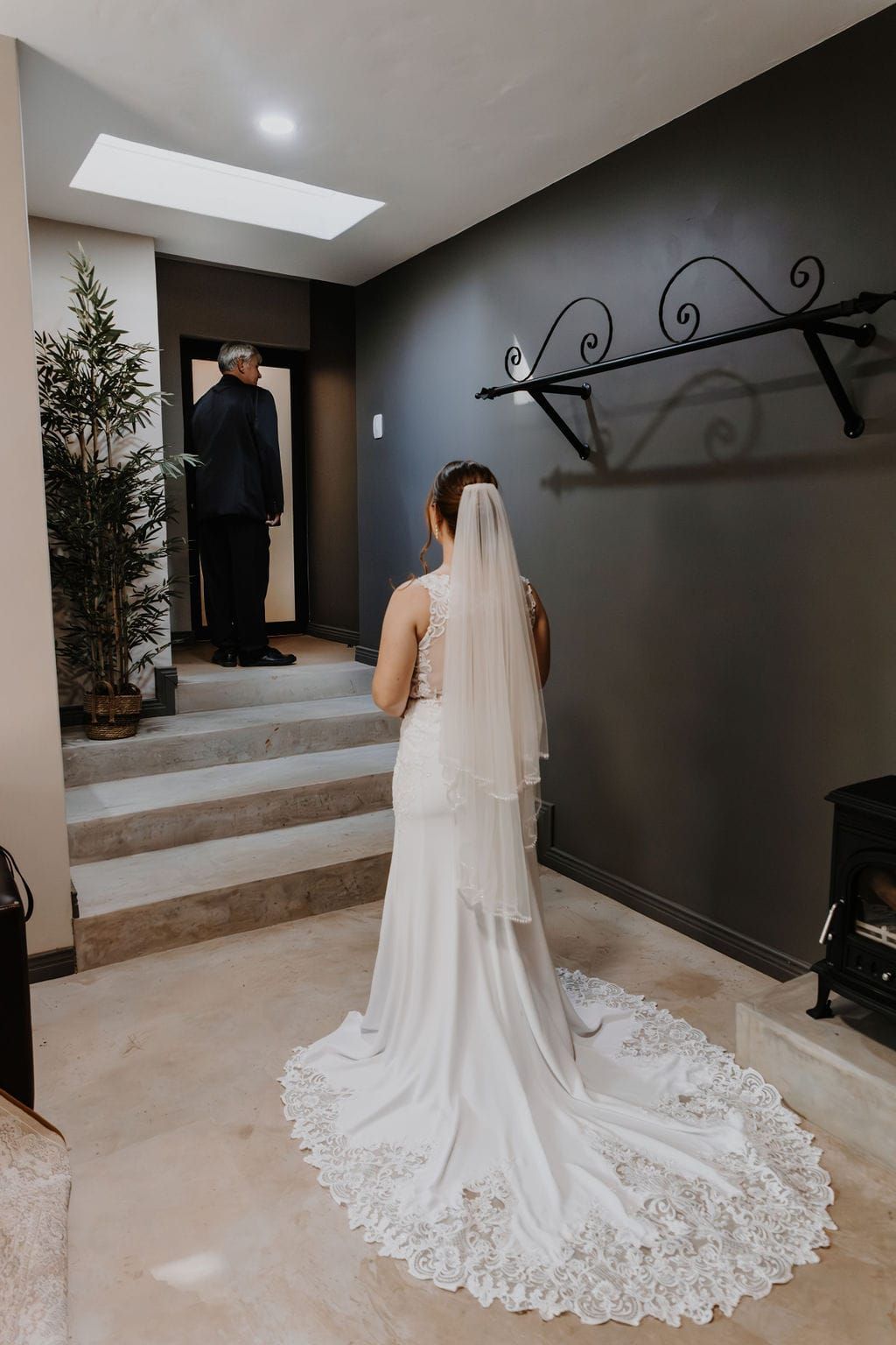 A bride in a wedding dress and veil is standing in a room.