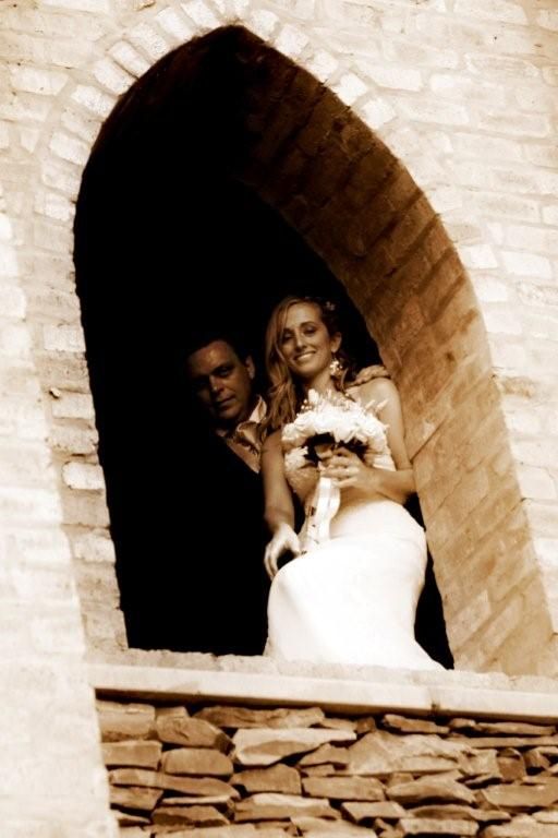 A bride and groom are posing for a picture in a window at Riverside Castle.