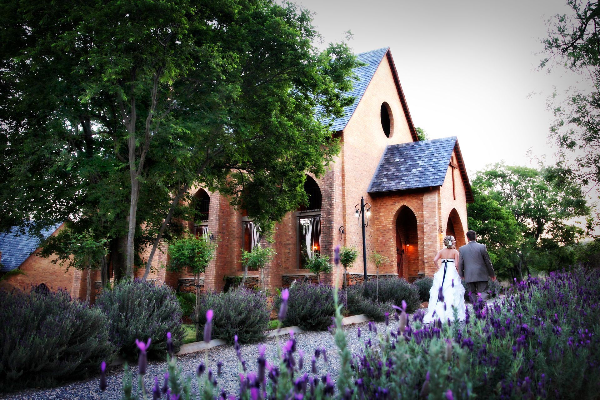 A bride and groom are standing in front of the chapel at Riverside Castle in Pretoria East.