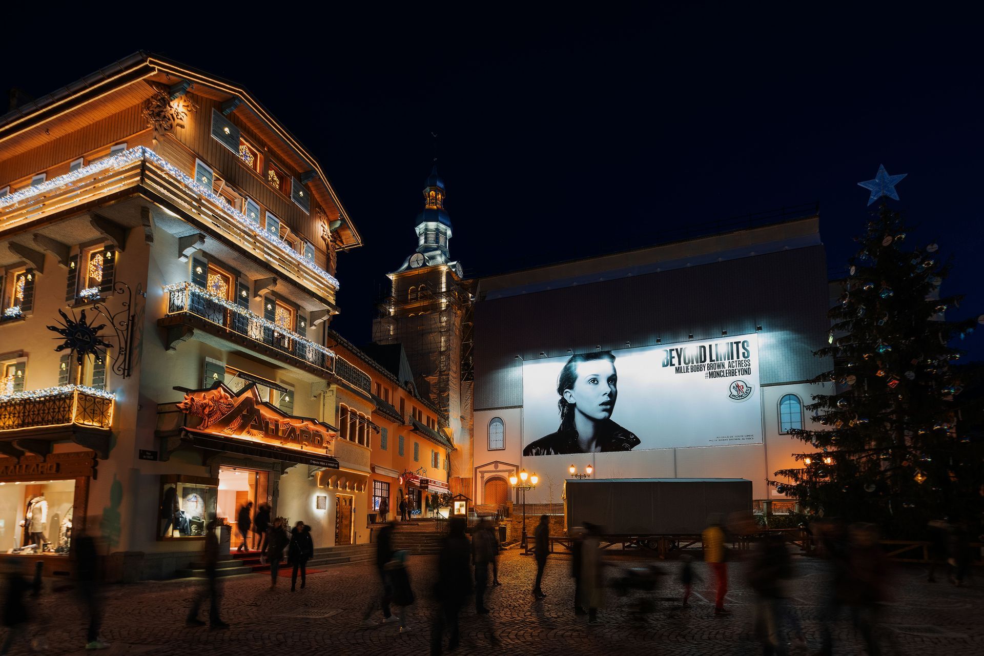 A large picture of a man is projected on the side of a building.