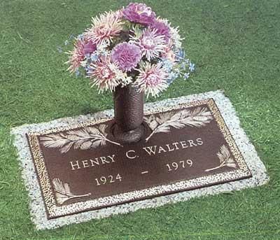 Gravestone for Henry C. Walters with a bouquet of pink and white flowers on green grass.