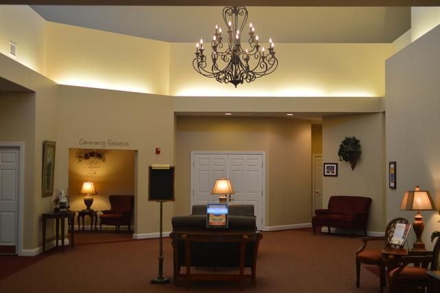 Quiet lobby with chandelier, central desk, warm wall lights, and seating area