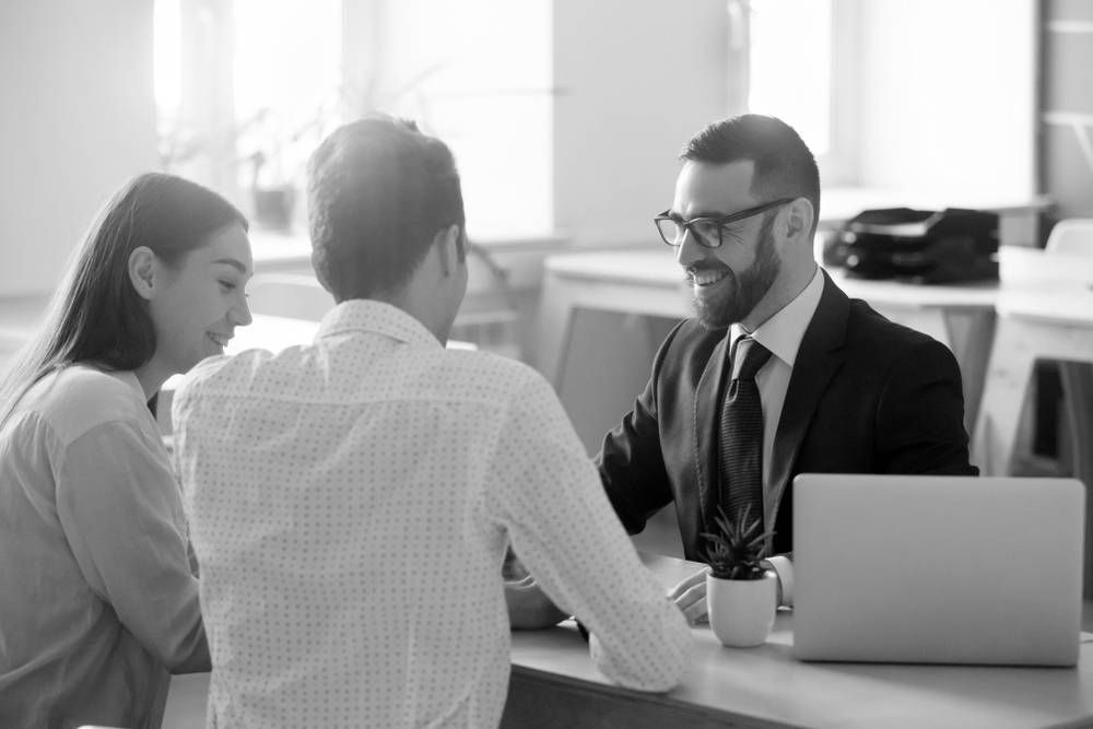 Couple Meeting With a Suited Advisor at a Desk — Paradise Law In Noosa, QLD