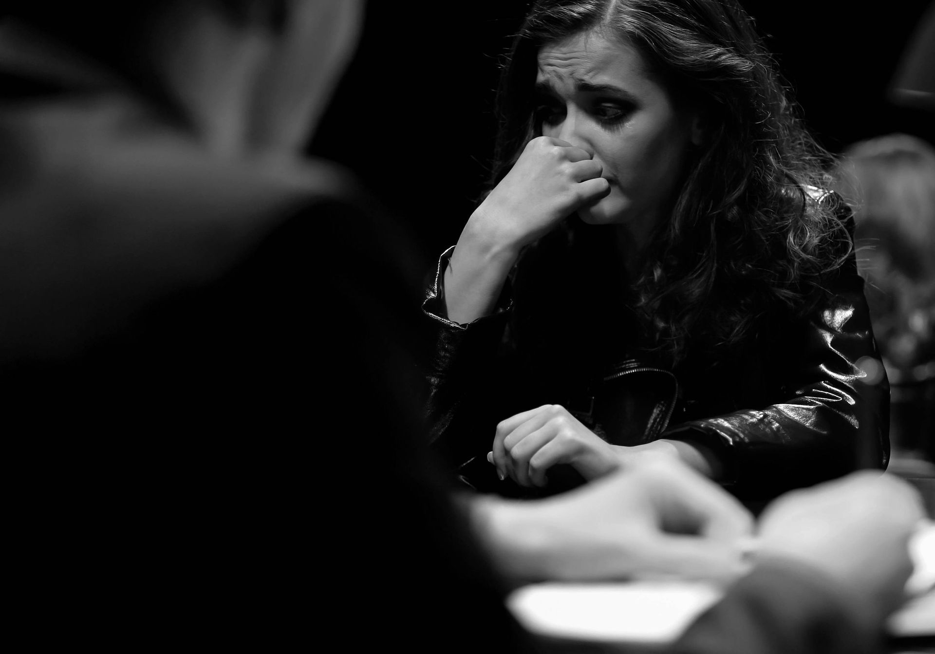 Woman Biting Her Nails, Looking Concerned, at a Table, Hands Visible in the Foreground — Paradise Law In Sandgate, QLD