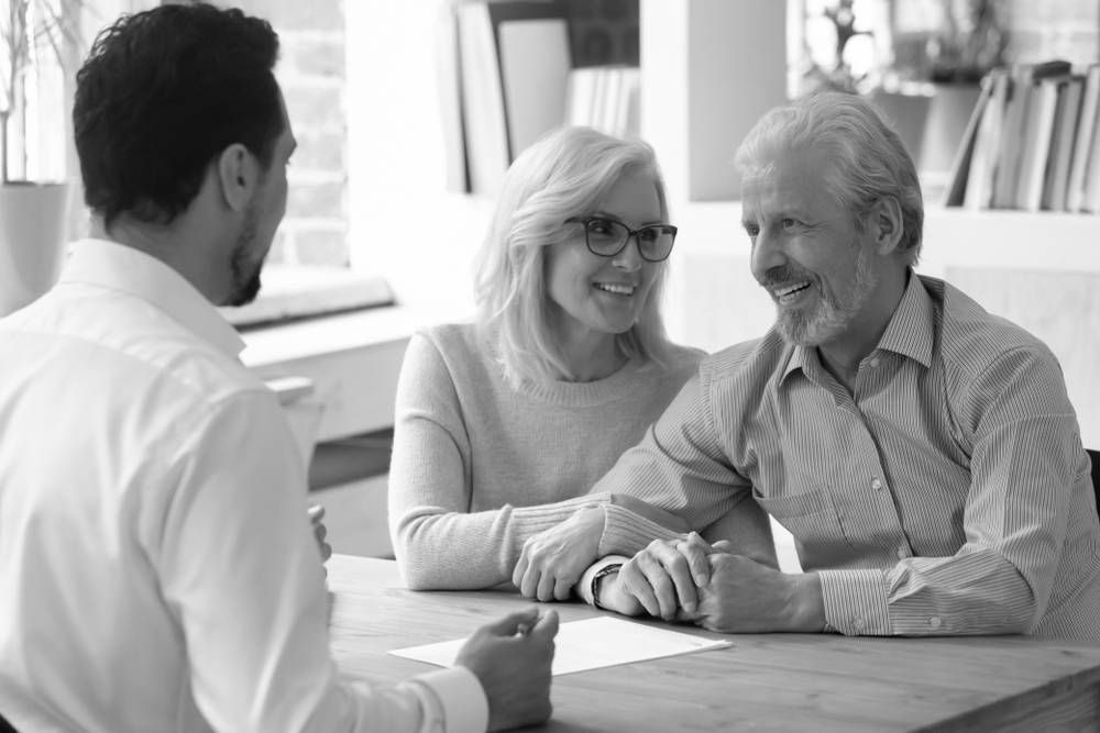 A Man in a Shirt Consults With an Older Couple Seated at a Table — Paradise Law In Beenleigh, QLD