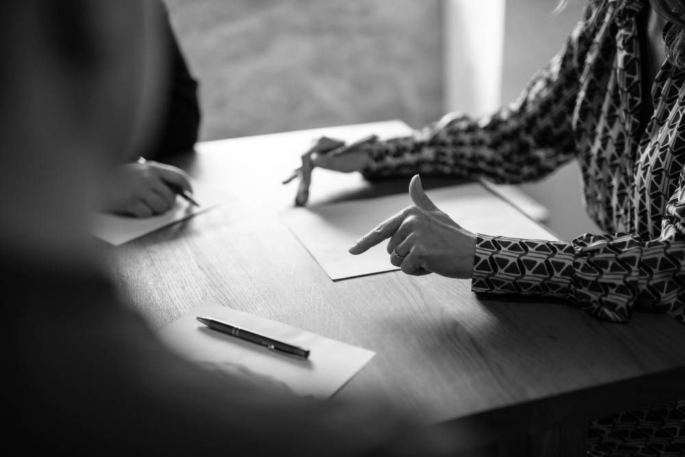 People at a Table, Pointing at Documents, Suggesting a Meeting or Discussion — Paradise Law In Noosa, QLD