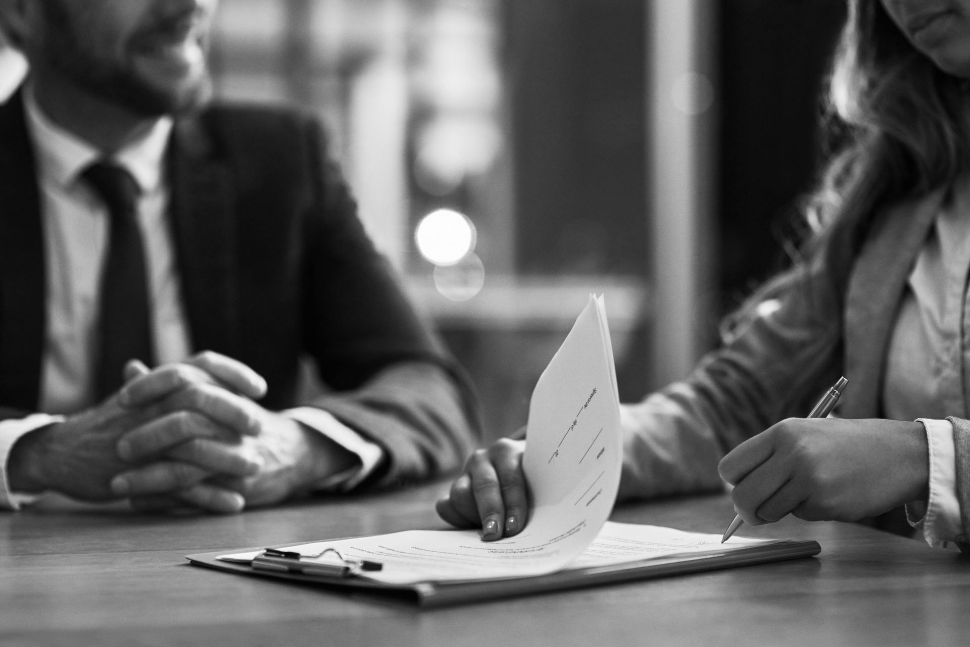 A Person Signing a Document on a Clipboard — Paradise Law In Gold Coast, QLD
