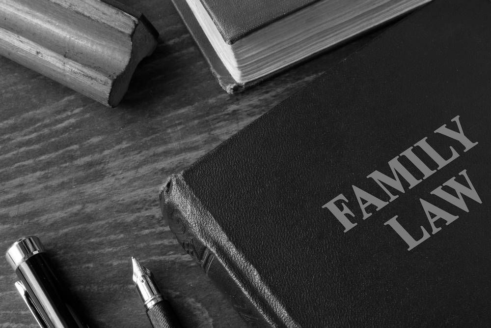 Family Law Book on a Wooden Surface With a Pen — Paradise Law In Redcliffe, QLD