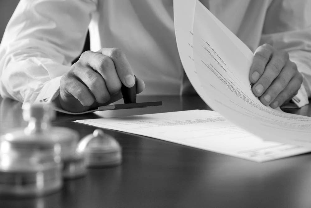 Person Stamping a Document With a Hand Stamp — Paradise Law In Noosa, QLD