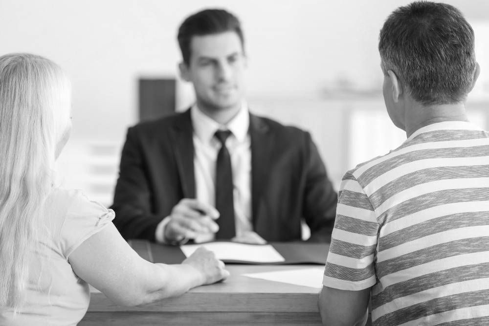 Couple Consulting With a Suited Professional at a Desk — Paradise Law In Surfers Paradise, QLD