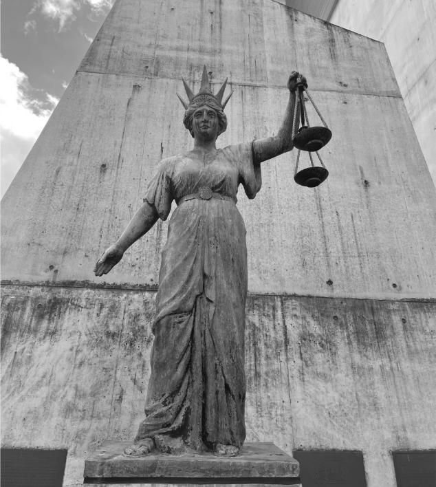 Statue of Lady Justice holding scales, in front of a concrete building — Paradise Law In Surfers Paradise, QLD