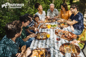 A group of people are sitting around a table eating food.
