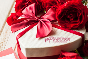 Red gift box with satin ribbon and roses on top, labeled Ponderosa