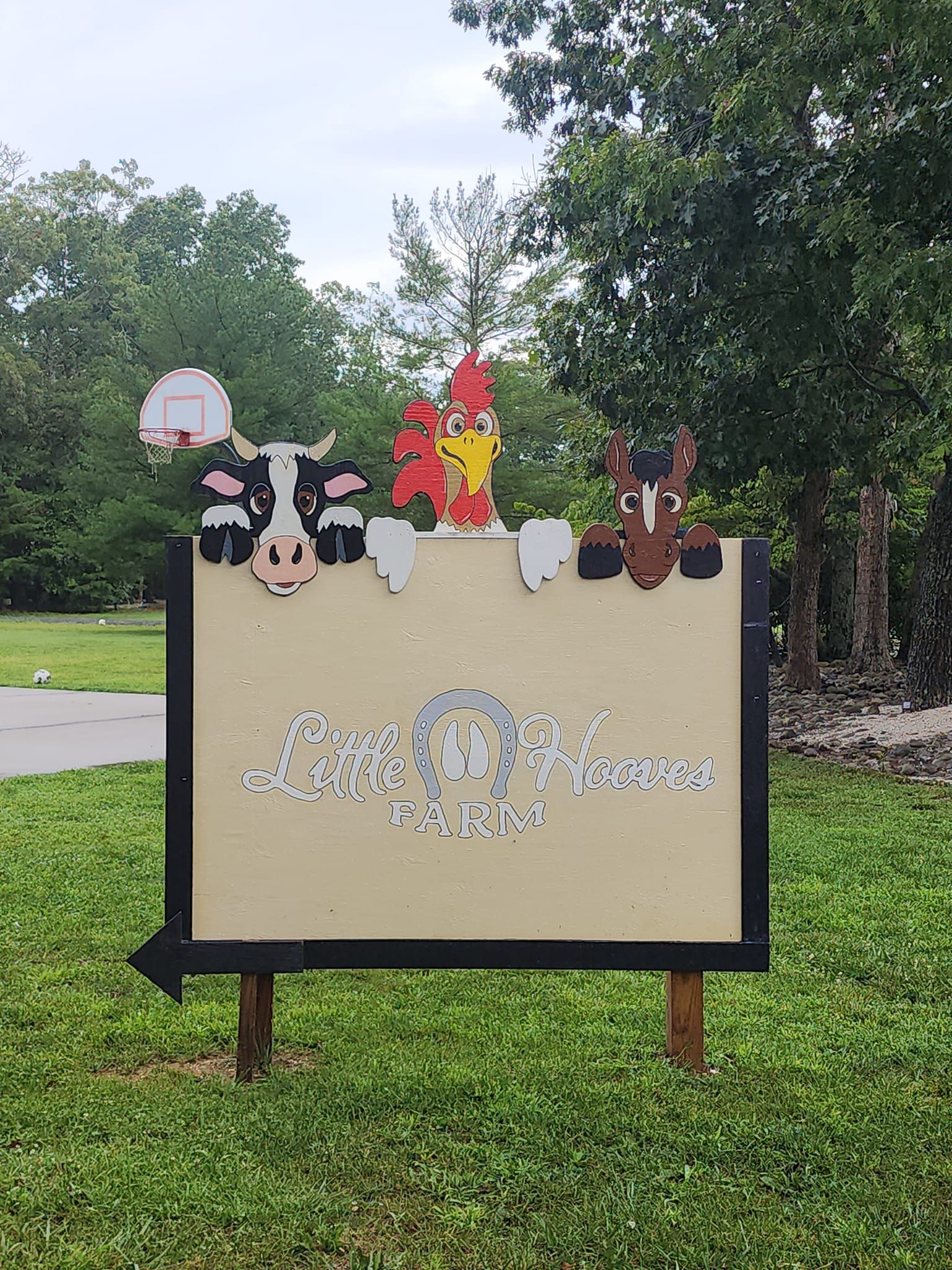 A sign with a cow , chicken , and horse on it.