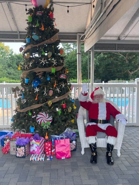 Santa claus is sitting in a chair in front of a christmas tree