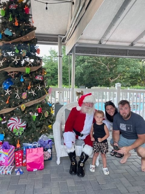 A family poses with santa claus in front of a christmas tree