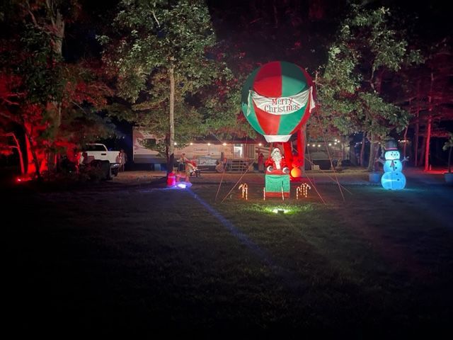 A hot air balloon with santa claus in it is lit up at night.