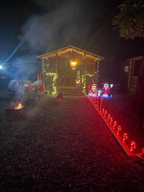 A house is decorated for christmas with red lights and santa claus.