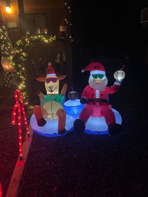 A couple of inflatable christmas decorations are sitting next to each other.