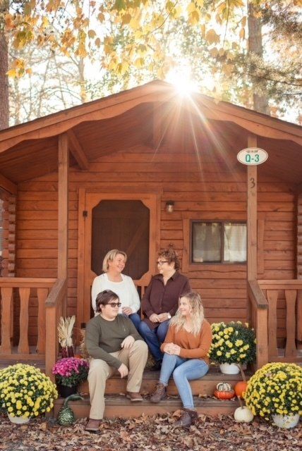 A group of people are sitting on the porch of a cabin.