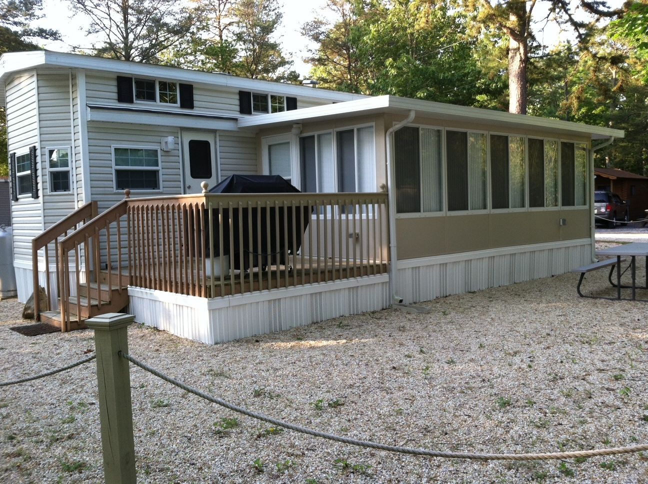 Modular home with screened porch and wooden deck in a wooded yard