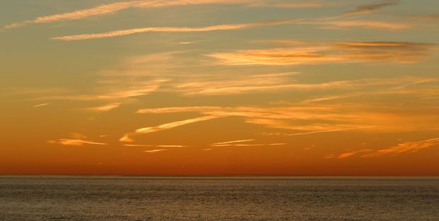 A sunset over the ocean with a lot of clouds in the sky