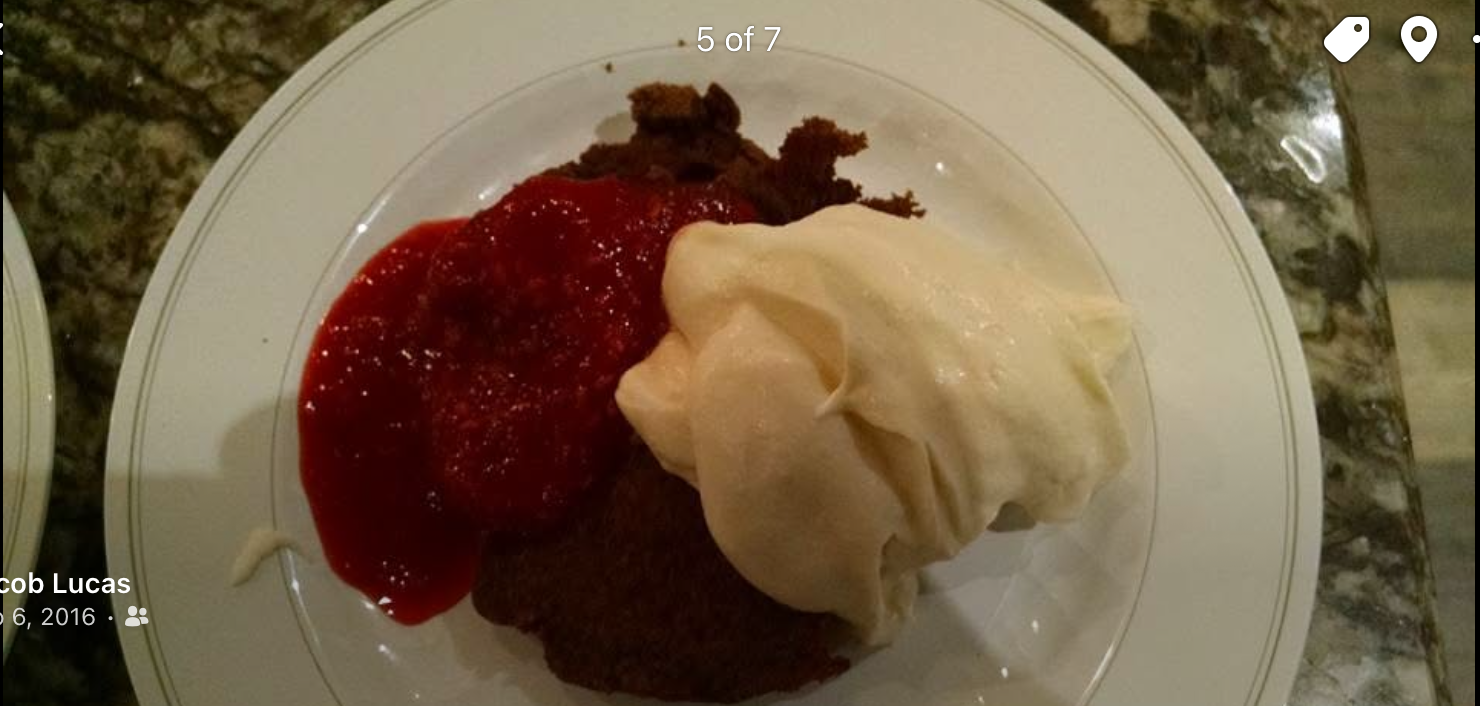 Dessert plate with strawberry topping and vanilla ice cream on a white dish