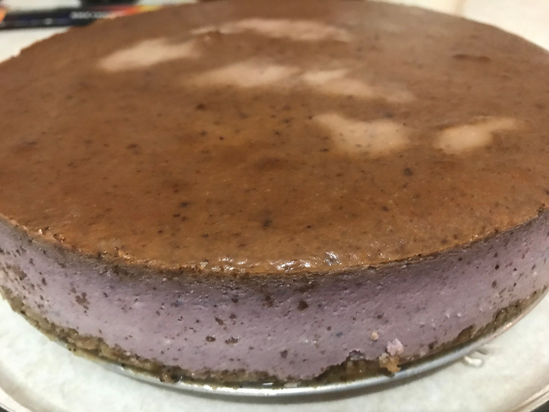 Chocolate-topped purple layered cake on a plate