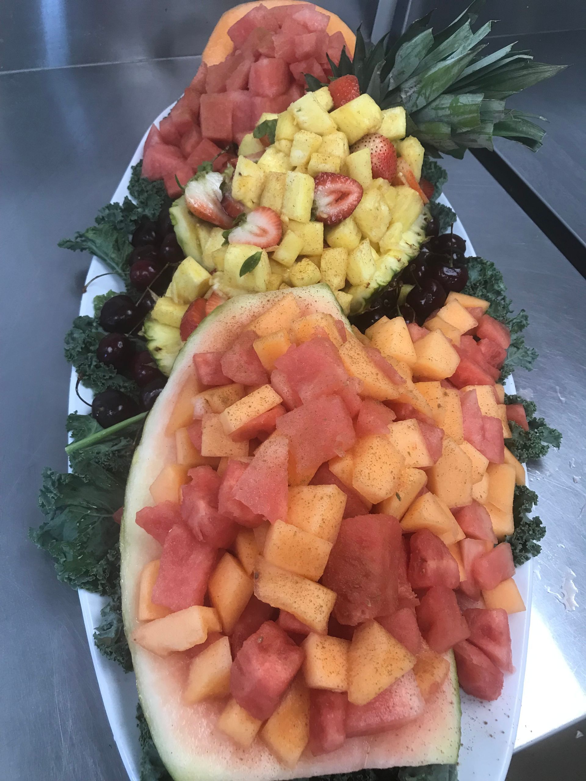 Fruit platter with carved watermelon and mixed tropical fruit arranged in a decorative display