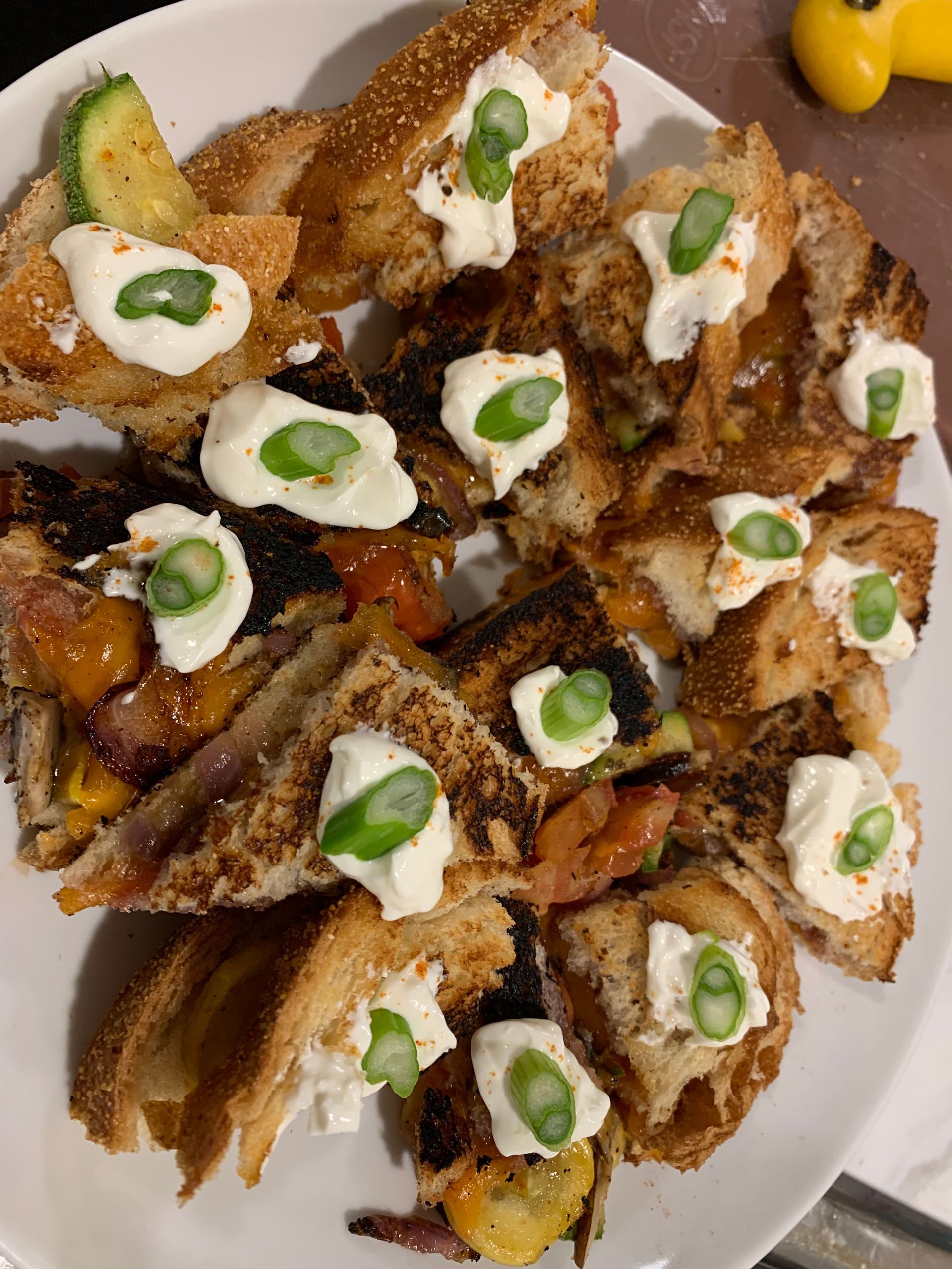 Taco salad topped with sour cream and green onions on a white plate
