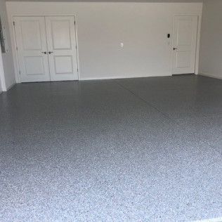A large empty room with a gray floor and white walls.