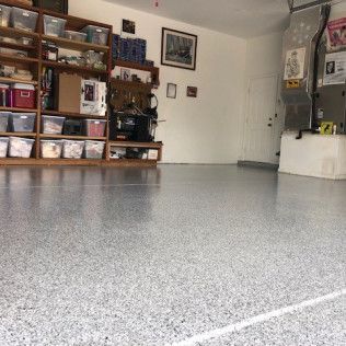 A garage with a gray floor and a lot of shelves.
