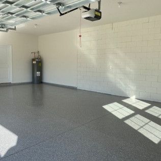 A garage with a gray floor and white brick walls.